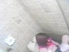 She masturbates in a toilet unaware of a spy camera watching her