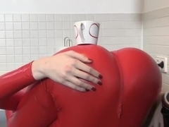 Flexible woman red latex catsuit redhead