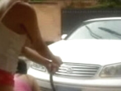 Cute little girls fooling around while washing a car