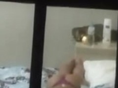 A window peep vid with a gal lying on the bed
